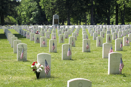 Photo of headstones adorned with American flags at Woodlawn National Cemetery.