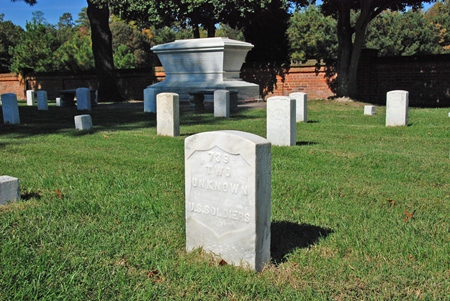 A headstone marking two unknown Civil War soldiers with the Tomb of the Unknown Soldier in the background at Cold Harbor National Cemetery.