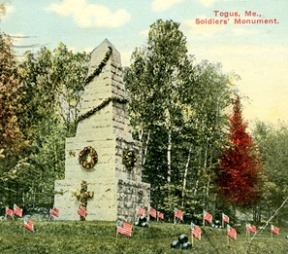 Vintage color view of monument (Soldier's Monument, Togus, Maine) decorated for Memorial Day, small US flags placed on ground.
